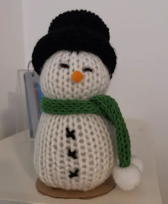 Muñeco de nieve tejido a mano — decoración navideña con sombrero de copa y bufanda